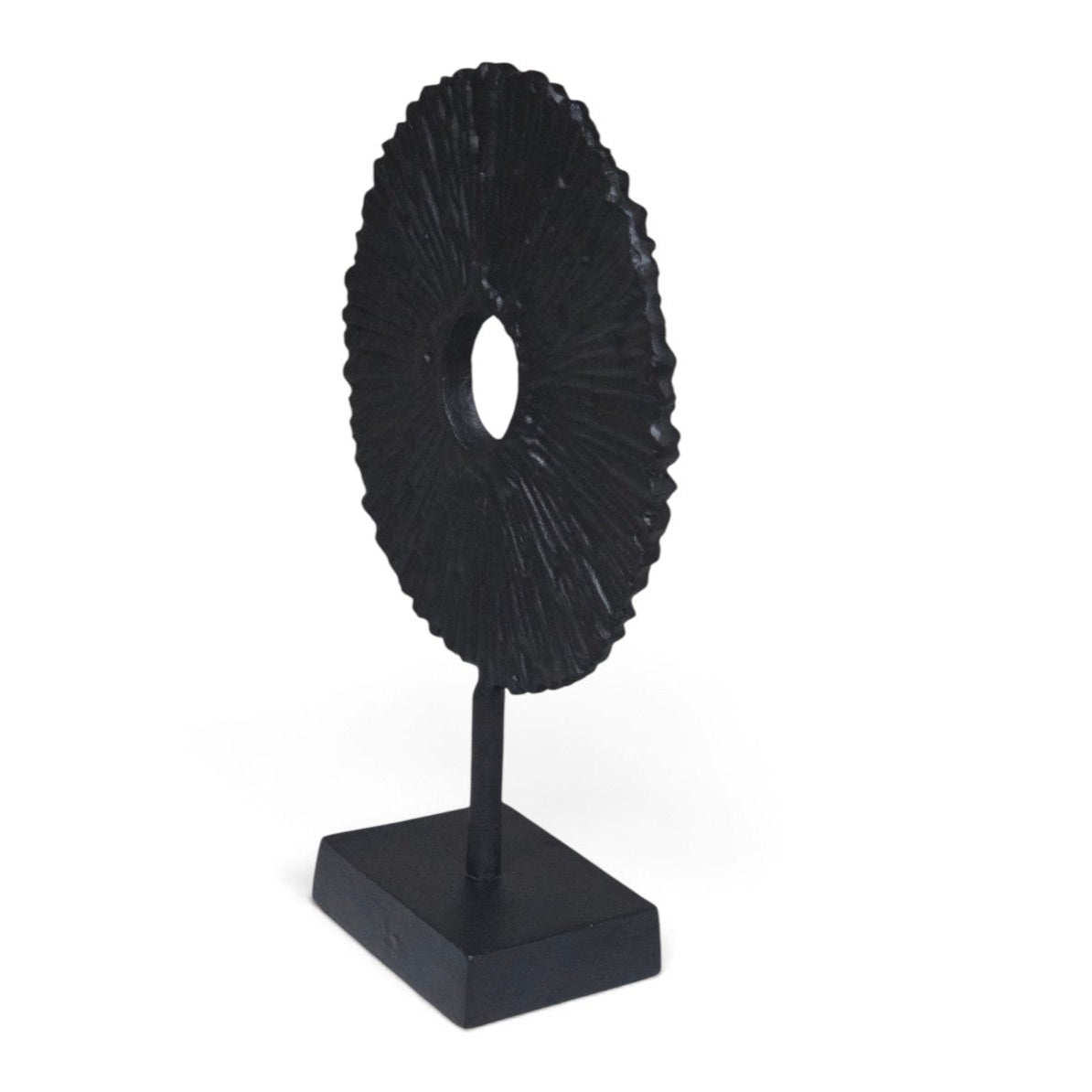 A black textured circular ring sculpture on a matching black square base stand, photographed against a solid white background.