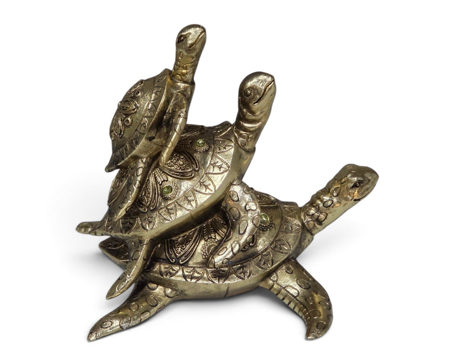 An ornate brass figurine depicting two turtles, one riding the other, with intricate engraved patterns and small green stone accents, set against a plain white background.