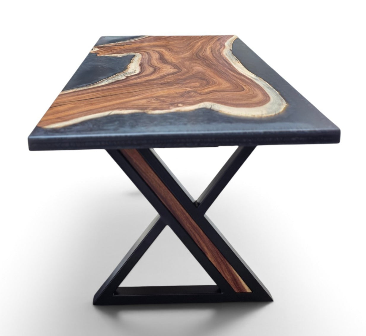 A rectangular table with a dark gray stone top featuring a prominent organic wood grain pattern, supported by a black metal X-shaped base with brown wood inlays.